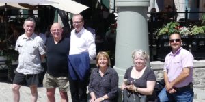 Nic stands outside in the sun with a group of Québec co-op members