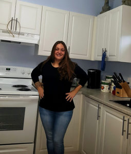 A co-op member stands proudly in a newly renovated kitchen.