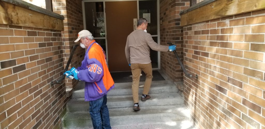 Two people clean outdoor handrails