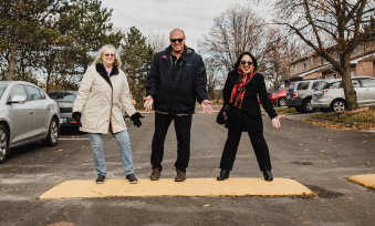 Three people gesture excitedly to a speed bump