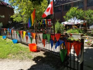 A sunny terrace decorated with Pride and Canada flags