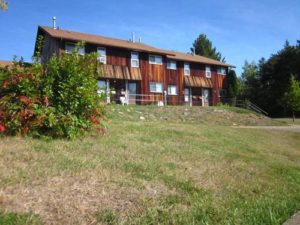 One of Castlegreen's rows of townhouses, on top of a grassy hill against a clear blue sky