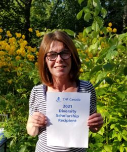 Carolyn holding up a Diversity Scholarship sign