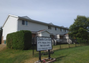 A row of townhouses with an Oasis Co-op sign