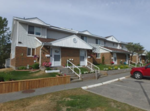 A row of brick and vinyl clad townhouses