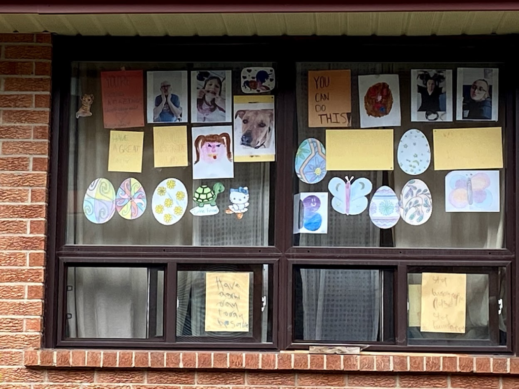 A window filled with drawings and paper easter eggs and butterflies