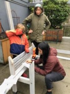 Two adults and a child build a planter