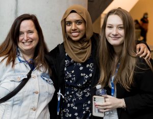 Three young women smile for the camera