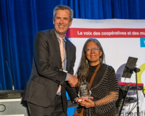 A man shakes hands with CHF Canada president Tina Stevens as she accepts an award