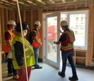 People tour the inside of an apartment under construction